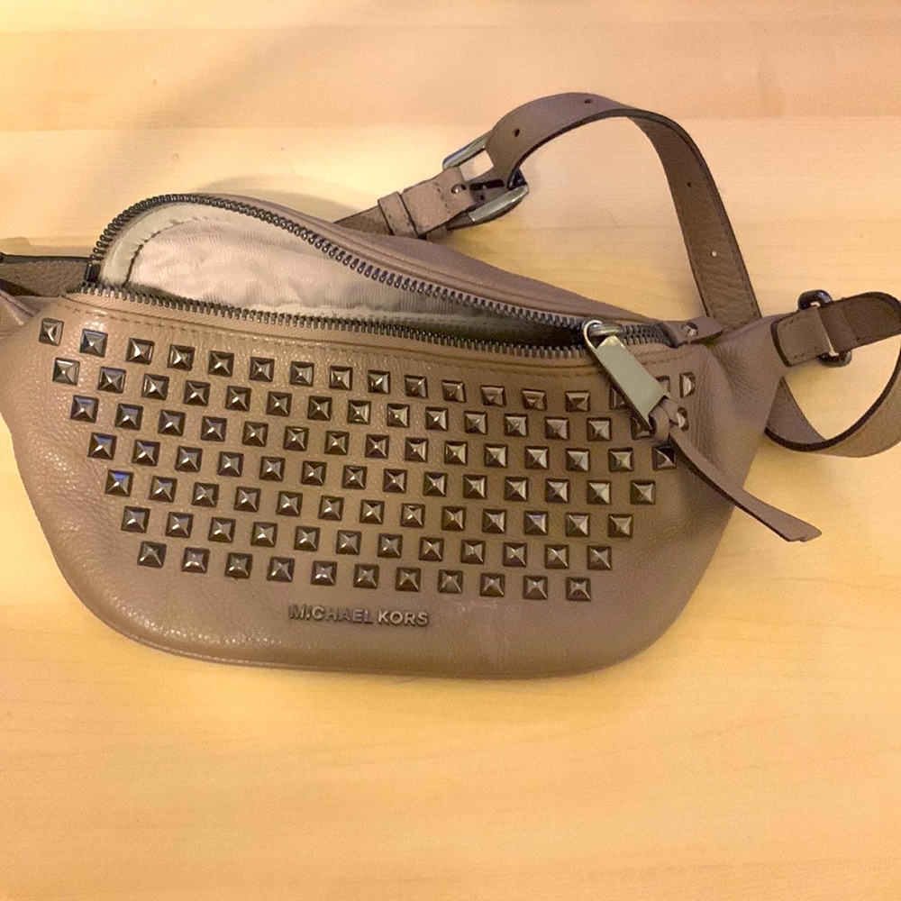 Michael Kors Rhea Zip Fanny Pack. Pebbled taupe leather with pyramid studs.